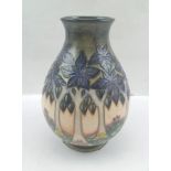 A MOORCROFT POTTERY VASE of squat baluster form, tube lined and glazed with a forest of blue leaf