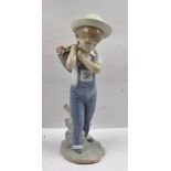 A LLADRO PORCELAIN FIGURE OF A BOY, carrying a basket of flowers over his shoulder, impressed and
