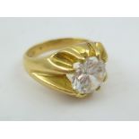 A GENTLEMAN'S DRESS RING set with a cubic zirconia, the yellow metal band not marked, considered