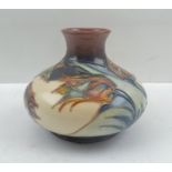A MOORCROFT POTTERY VASE of squat form, tube lined and glazed in "Red Tulip" pattern, designed by