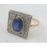 AN 18CT GOLD SQUARE HEAD LADY'S DRESS RING set large oval sapphire with diamond surround