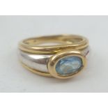 A TWO COLOUR 9CT GOLD RING set oval blue zircon, stamped .375