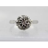 A WHITE GOLD DIAMOND CLUSTER RING, bears marks considered to be 18ct., size K