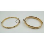 TWO 9CT GOLD "METAL CORE" BANGLES, having diamond pattern decoration, both with safety chains