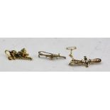 A 9CT GOLD STOCK PIN in the form of a hunting crop, mounted with a fox mask and a horse bit, 4cm,