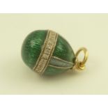 A RUSSIAN OVOID FORM CHARM PENDANT having green guilloche enamel with a band of diamonds, suspension