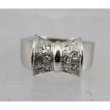 A BELIEVED TO BE 18K (bears various marks) WHITE GOLD "BOW" RING set fourteen diamonds, size P