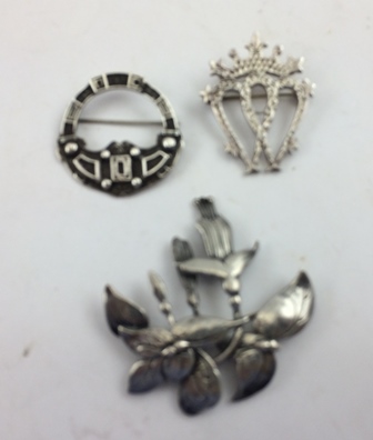 THREE VARIOUS SILVER BROOCHES includes an Art Nouveau of fuchsia design and another of Celtic design