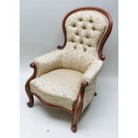 A 19TH CENTURY MAHOGANY SHOW WOOD FRAMED BUTTON BACKED ARMCHAIR with all over old gold upholstery,