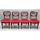 A SET OF FOUR VICTORIAN MAHOGANY FINISHED BALLOON BACK STYLE DINING CHAIRS, each with carved central