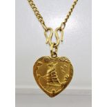 A CHINESE YELLOW METAL HEART SHAPED PENDANT, cast with a sail ship on one side and character marks