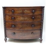 A 19TH CENTURY MAHOGANY BOW FRONTED CHEST OF DRAWERS, having plain top, turned column side supports,