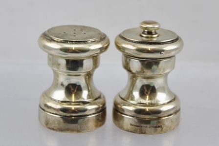 TIFFANY A PAIR OF SILVER CONDIMENTS of waisted form, the pepper being an operative grinder,