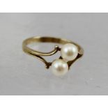 A 9CT GOLD RING, set with two cultured pearls, within a jeweller's ring box