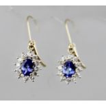 A PAIR OF GOLD TANZANITE AND DIAMOND CLUSTER EARRINGS with hoop fastenings