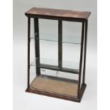 AN EDWARDIAN MAHOGANY FRAMED COUNTER TOP DISPLAY CABINET, having sloping front, fitted two