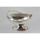 WILLIAM AITKEN AN EDWARDIAN SILVER SWEETMEAT DISH of Regency oval form with reeded swing handle,