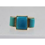 A 9CT GOLD LADY'S TURQUOISE DRESS RING, set with a central square form turquoise, flanked by a