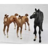 A ROYAL DOULTON MATT BLACK FINISHED CERAMIC FOAL with one white sock, together with TWO FROLICKING
