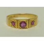 A VICTORIAN 18CT GOLD LADY'S DRESS RING set three rubies, ring size I