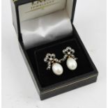 A PAIR OF EARRINGS, diamond set of bow design with cultured pearl droppers and pierced fittings,