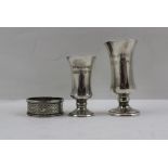 THREE PIECES OF HALLMARKED SILVER, being two tots and an engine chased napkin ring