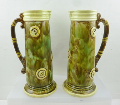 A PAIR OF EARLY 20TH CENTURY MAJOLICA JUGS, tapering cylindrical form, mottled glaze with strap work