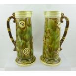 A PAIR OF EARLY 20TH CENTURY MAJOLICA JUGS, tapering cylindrical form, mottled glaze with strap work