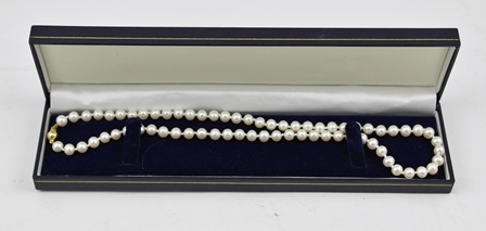 A SINGLE STRAND OF CULTURED PEARLS with 9ct gold clasp, in vendor's case