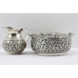 AN INDIAN WHITE METAL CREAM JUG AND A BOWL with fluted rim, chased acanthus leaf decoration,