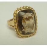A 9CT GOLD LADY'S DRESS RING set large citrine within a rope design surround, size L and half