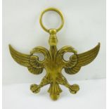 A CAST BRASS PRUSSIAN DESIGN DOUBLE-HEADED EAGLE, with ring suspension, 24cm high