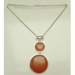 A SILVER AND RED HARDSTONE SET PENDANT on silver chain