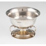 A silver bowl, with three scroll supports and raised on a circular stepped foot, hallmarked London