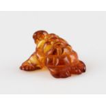 A piece of carved amber in the shape of a turtle, length approx. 20mm.
