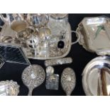 A silver dressing table set with two silver topped bottles and a selection of various silver