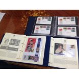 A collection of Royal Commemorative FDCs some with coins, four albums including The Queens Golden