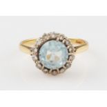 An aquamarine and diamond cluster ring, set with a round cut aquamarine, diameter approx. 8mm,