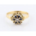 A sapphire and diamond flower design ring, set with a central eight cut diamond, surrounded by round