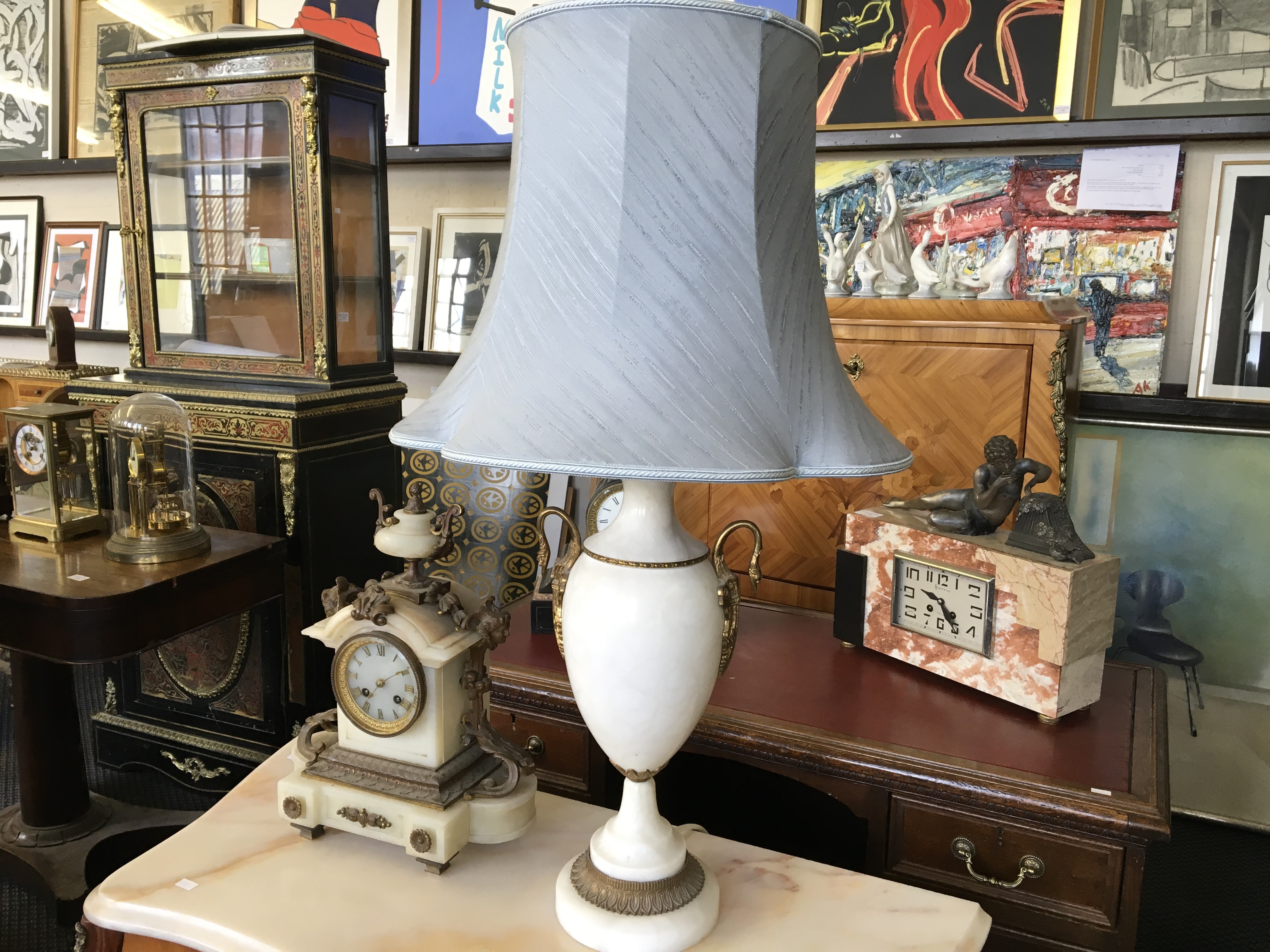 A white marble table lamp with swan neck decoration.