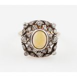 An opal and diamond cluster ring, set with a central oval cut opal, measuring approx. 8x6mm,