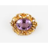 An amethyst brooch, set with a central oval cut amethyst, measuring approx. 15x11mm, surrounded by