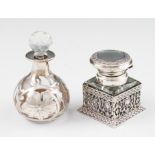 A silver mounted ink well, the square glass body surrounded by open metalwork with hinged lid,