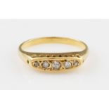 A five stone diamond ring, set with five graduated round cut diamonds, set in unmarked yellow metal,