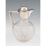 An early 20th Century silver lidded and handled glass decanter, body featuring cut circular