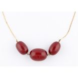 A cherry Bakelite necklet, comprising of three graduated cherry Bakelite beads, the largest