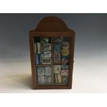 A selection of various advertising needle boxes in a display cabinet.