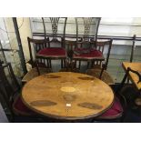A walnut topped Edwardian breakfast table and seven chairs.