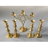 Two pairs of brass candlestick holders with one three branch candlestick holder.