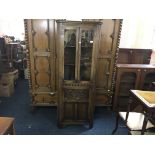 A reproduction oak corner cabinet with two doors to top and cupboard base.